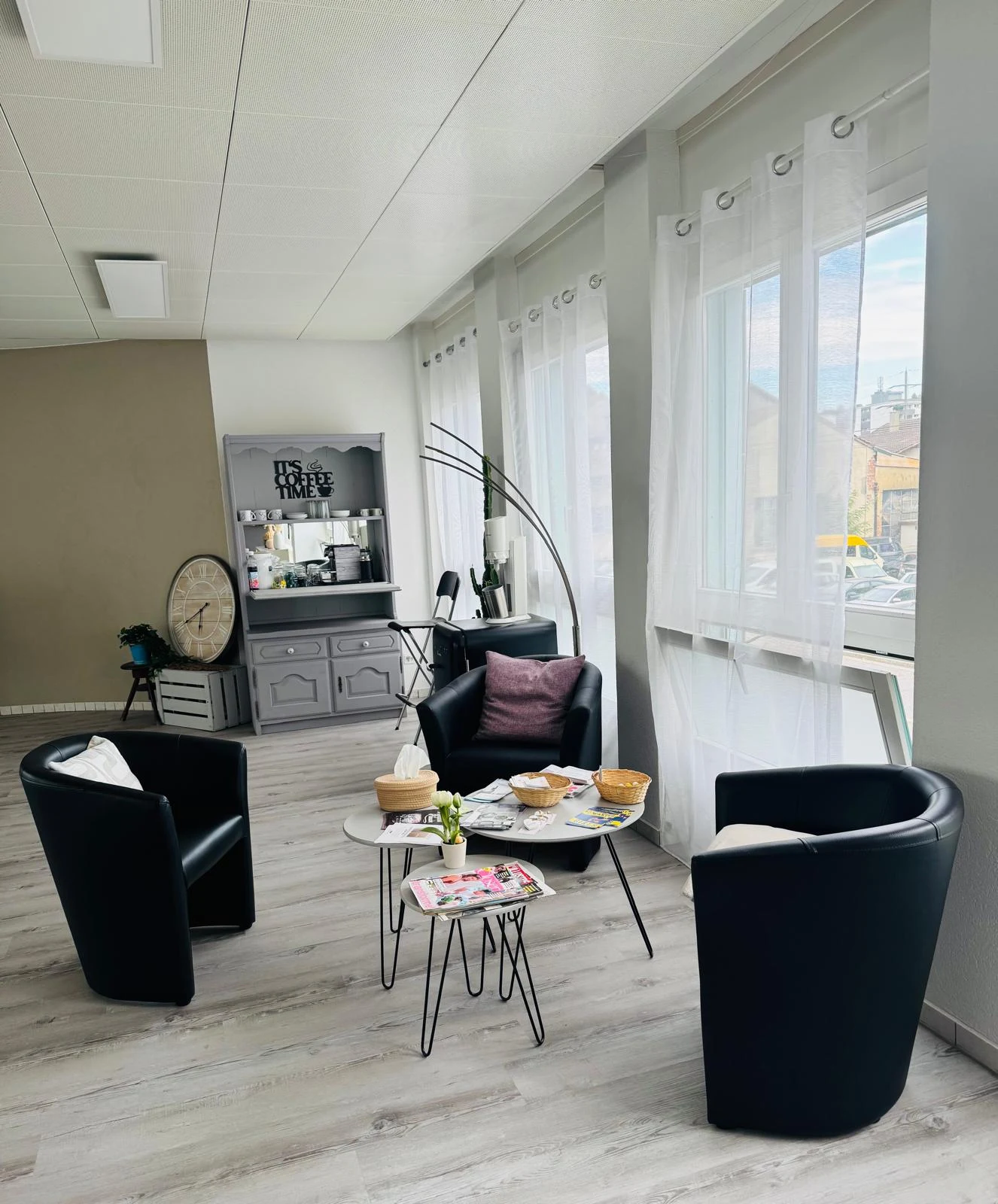 Coin convivial de la salle à louer, avec fauteuils et espace café près des fenêtres